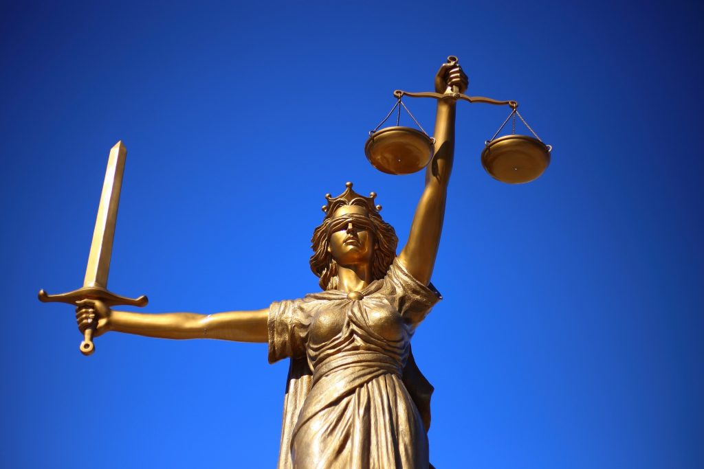 gold lady justice against blue sky